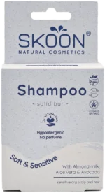 Pureday Billede af Skoon shampoo bar - Sensitiv hypoallergen æske, designet med velvære og helbred i tankerne. Det er allergivenligt og parfumefrit og indeholder naturlige ingredienser som mandelmælk, aloe vera og avocado. Den hvide emballage viser blå tekst og viser dens veganske certificeringer.