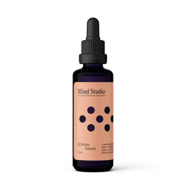 Pureday En glasdråbeflaske Kosttilskud shiitake - Svampe Ekstrakt - Øko, med en violet etiket med sorte prikker, vist mod en sort og ferskenfarvet baggrund. Med vægt på økologi, den